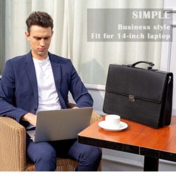 Άνδρας με κουστούμι μπλε δουλεύει το Laptop του με τον Χαρτοφύλακα Cardinal στο τραπέζι .