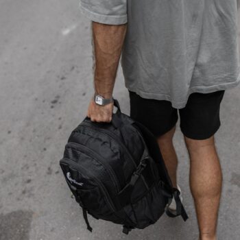 Σακίδιο πλάτης μαύρο με άνδρα να το κρατάει στην πόλη .