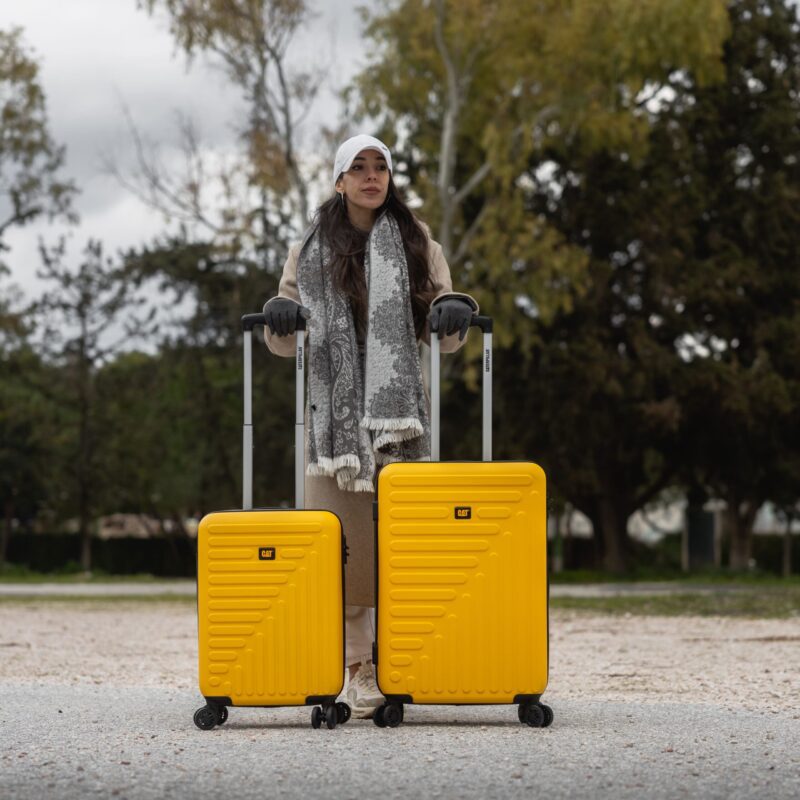 Βαλίτσες σετ κίτρινες καμπίνας και μεσαία με ανδρα να τις κρατάει