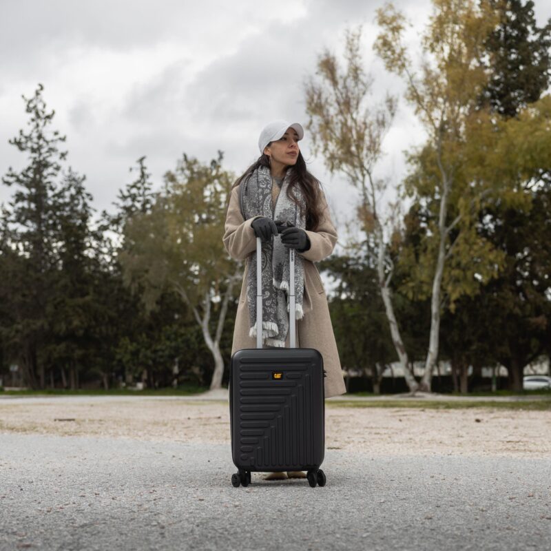 Βαλίτσα καμπίνας caterpillar σε μαύρο χρώμα με γυναίκα να την κρατάει