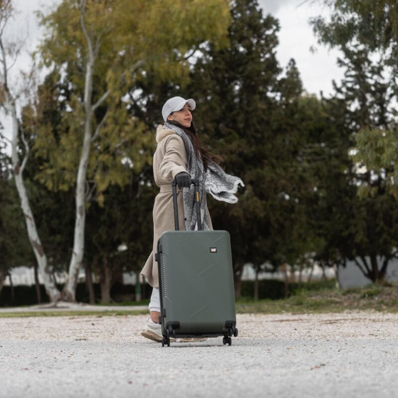 Βαλίτσα μεσαία σκληρή σε χακί χρώμα με άνθρωπο να την κρατάει
